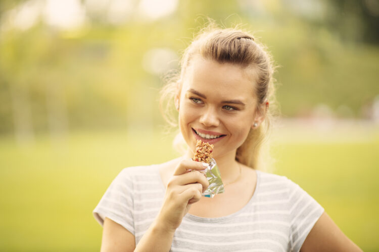 Når følingsmaden går ud ocer tandsundheden. Kvinde med energibar